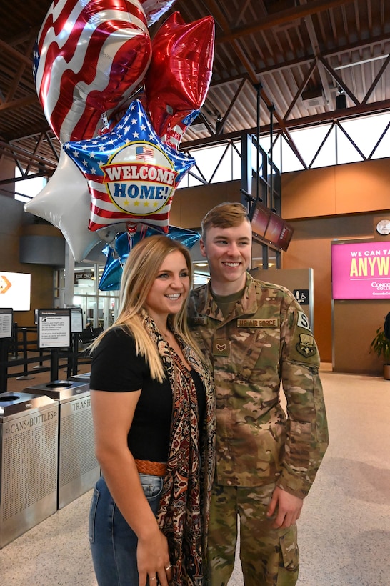 Photo of Senior Airman Brian being greeted by his girl friend as he returns home to Hector International Airport, Fargo, N.D., upon his completion of deployment Feb. 5, 2020.