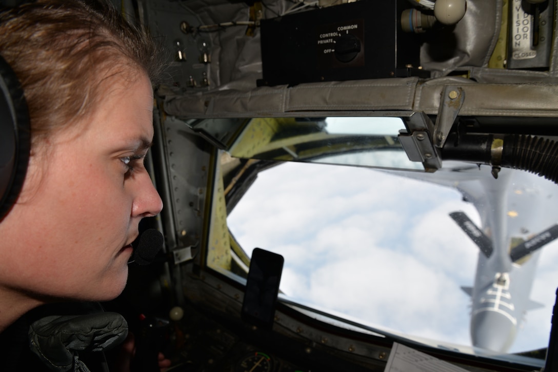 An airman looks out the window of a military aircraft during an aerial refueling.