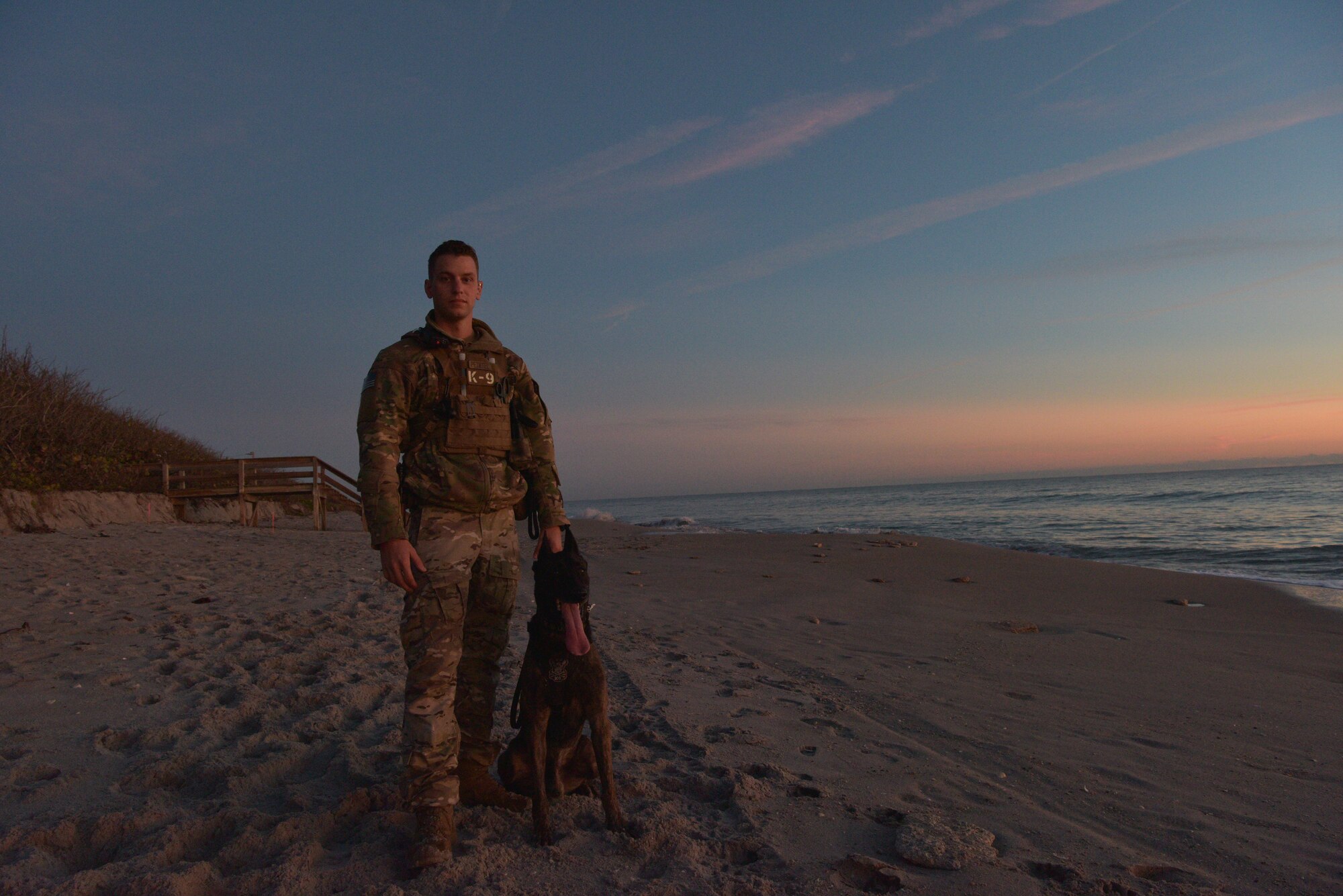 Staff Sgt. Kyle Pethtel, 45th Security Forces Squadron military working dog handler, poses for a photo with Pieter, his military working dog, at Patrick Air Force Base, Fla., Nov. 26, 2019. Pethtel and Pieter have been a MWD team since July 2019. (U.S. Air Force photo by Senior Airman Dalton Williams)
