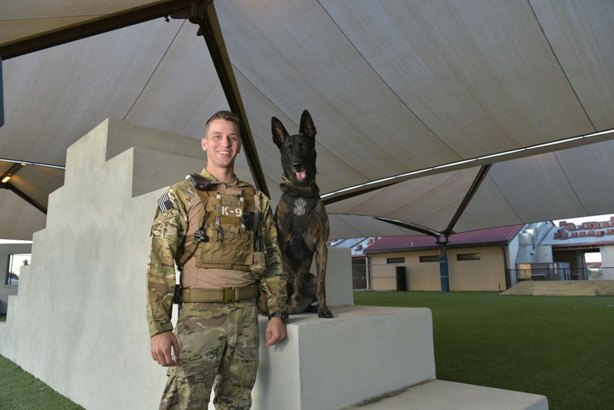 Staff Sgt. Kyle Pethtel, 45th Security Forces Squadron military working dog handler, poses for a photo with Pieter, 45th SFS military working dog, at Patrick Air Force Base, Fla., Nov. 26, 2019. Pethtel and Pieter have been a MWD team since July 2019. (U.S. Air Force photo by Senior Airman Dalton Williams)