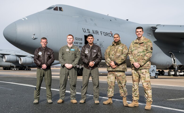 C-5M Super Galaxy 9th Airlift Squadron aircrew members pose for a photo Feb. 4, 2020, on Dover Air Force Base, Del. From the left are five of the 12 Reach 190 members: Capt. Geoffrey Howard, aircraft commander; Tech. Sgt. Alexander Barnes, flight engineer; Master Sgt. Joshua Cutrer, loadmaster; Staff Sgt. Teagan Young, 436th Aircraft Maintenance Squadron flying crew chief; and 1st Lt. Eli Parsch, pilot. (U.S. Air Force photo by Roland Balik)