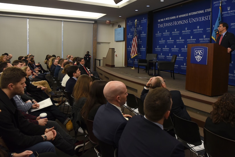 A man stands at a podium and talks into a microphone.