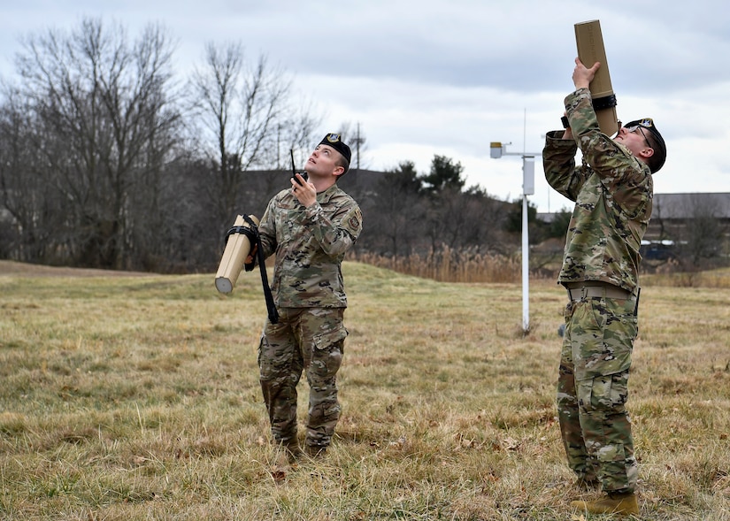 Photo of two Airman using Dronebuster technology in a field.