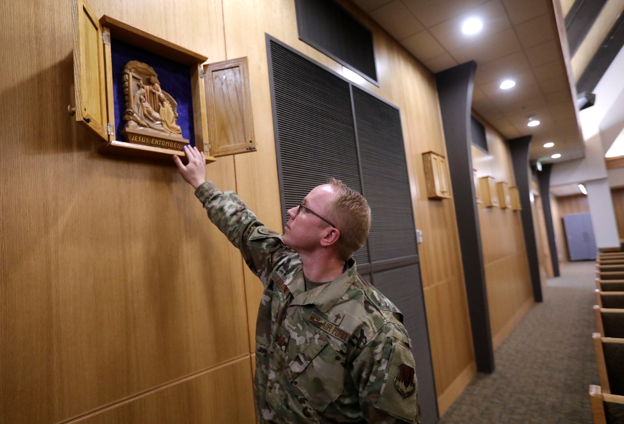 Capt. J. Ammon Larsen, a chaplain at Hill Air Force Base, shows how depictions of the Stations of the Cross in the base's sanctuary.
