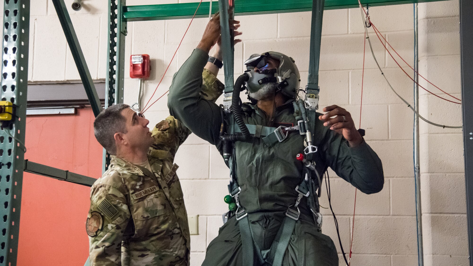 Karl Malone (right), NBA Hall of Famer, uses a parachute simulator while receiving training from Master Sgt. Martin Ruemenapp Jr. (left), 2nd Operation Support Squadron survival, evasion, resistance and escape flight chief at Barksdale Air Force Base, La., Feb. 4, 2020. Malone received training from the 96th Bomb Squadron and the 2nd Operations Support Squadron in the case of an emergency. (U.S. Air Force photo by Airman 1st Class Jacob B. Wrightsman)