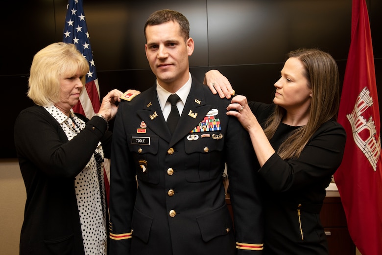 Maj. Justin Toole, U.S. Army Corps of Engineers Nashville District deputy commander, gets help putting on lieutenant colonel epaulettes by his mom Arlene (Left) and wife Katy during a ceremony at the Nashville District Headquarters in Nashville, Tennessee, Feb. 6, 2020. (USACE Photo by Lee Roberts)