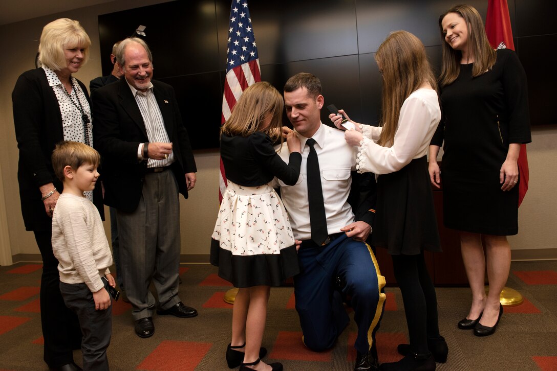 Maj. Justin Toole, U.S. Army Corps of Engineers Nashville District deputy commander, is supported by his family as his daughters Mya (Left) and Caroline put lieutenant colonel shoulder boards on his uniform during a promotion ceremony at the Nashville District Headquarters in Nashville, Tennessee, Feb. 6, 2020. From Left to Right supporting are his son Ben, mother Arlene, father Rick, and wife Katy. (USACE Photo by Lee Roberts)