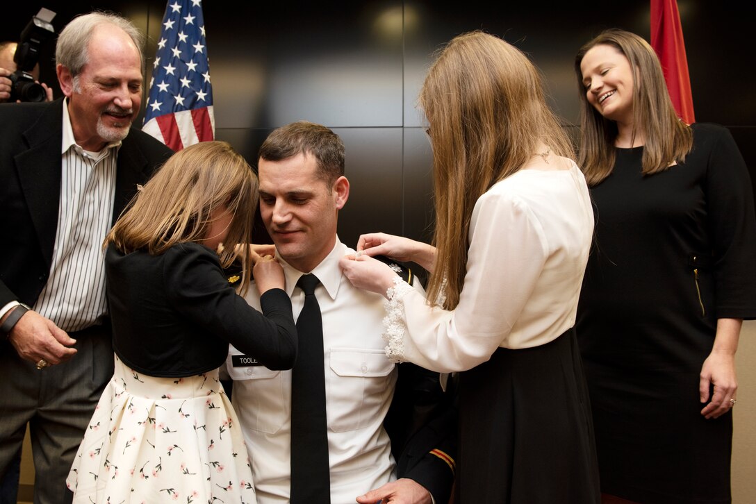 Maj. Justin Toole, U.S. Army Corps of Engineers Nashville District deputy commander, watches as his daughters Mya (Left) and Caroline put lieutenant colonel shoulder boards on his uniform during a promotion ceremony at the Nashville District Headquarters in Nashville, Tennessee, Feb. 6, 2020. His father Rick and wife Katy watch the girls help to promote their dad. (USACE Photo by Lee Roberts)