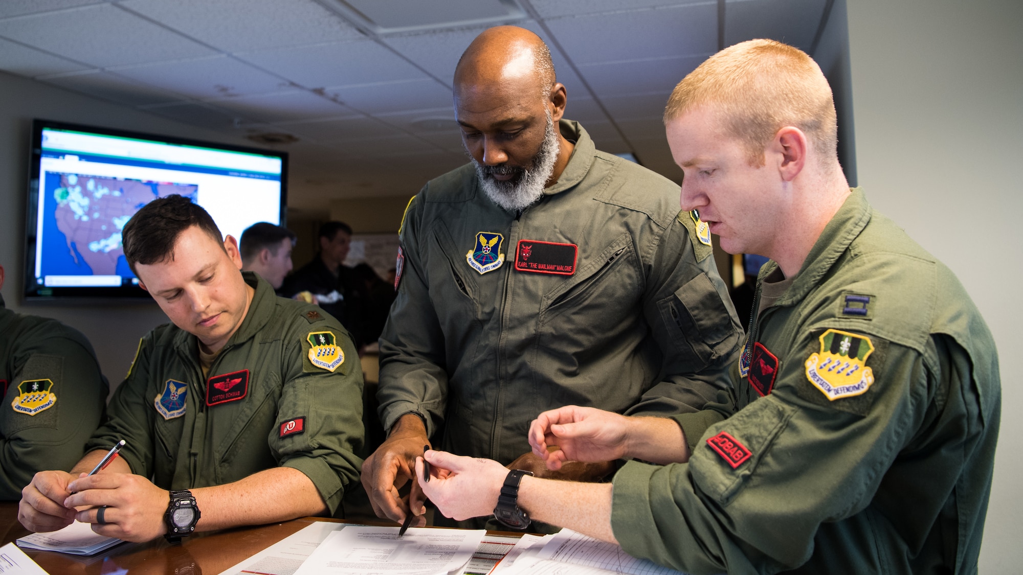 Karl Malone (center), NBA Hall of Famer, recieves a pre-flight brief prior to his flight with the 96th Bomb Squadron at Barksdale Air Force Base, La., Feb. 5, 2020. Malone spent time with Airmen, toured facilities and even took a ride in a B-52H Stratofortress. (U.S. Air Force photo by Airman 1st Class Jacob B. Wrightsman)