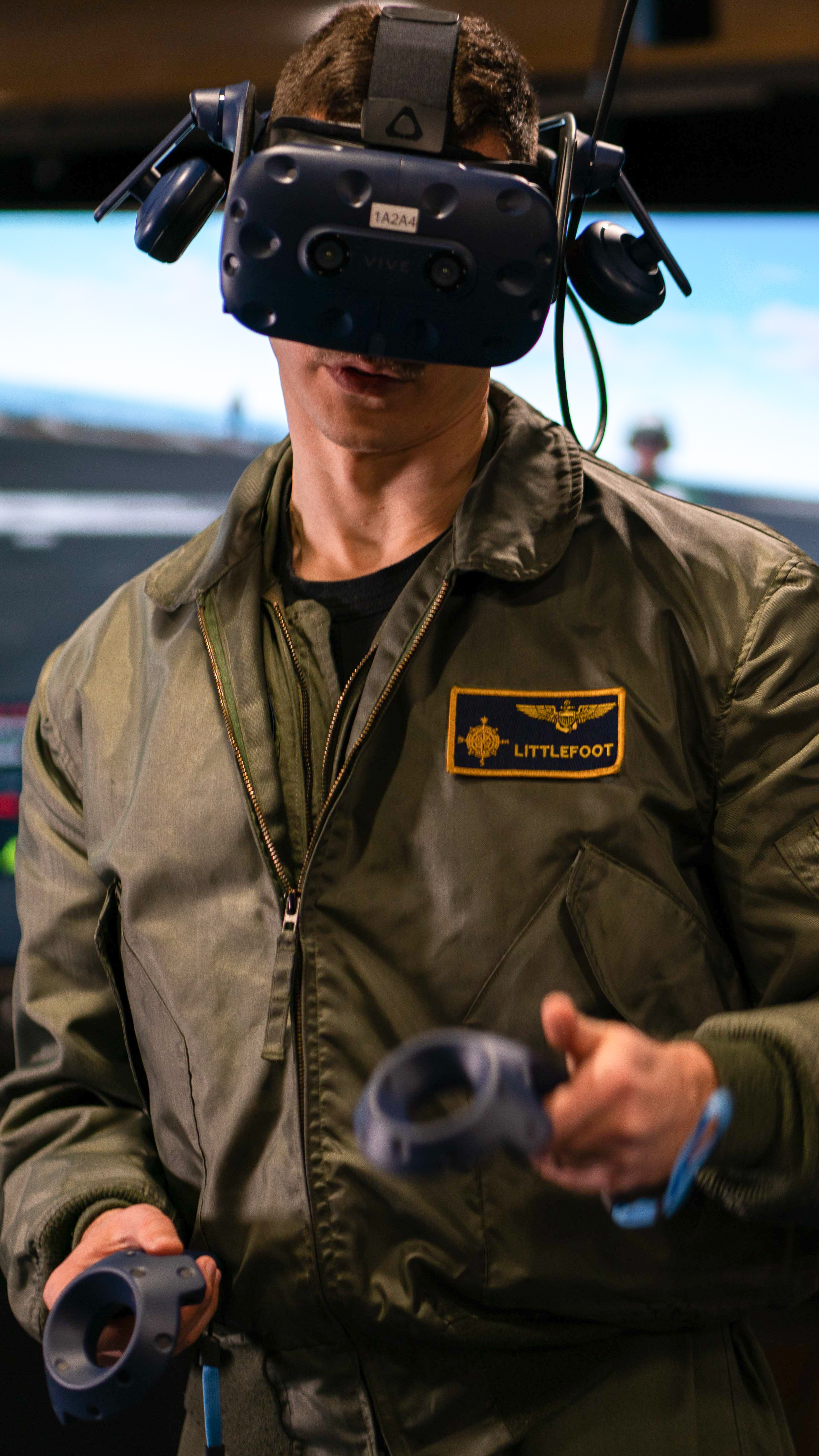 A Sailor operates a virtual reality computer though the use of a headset