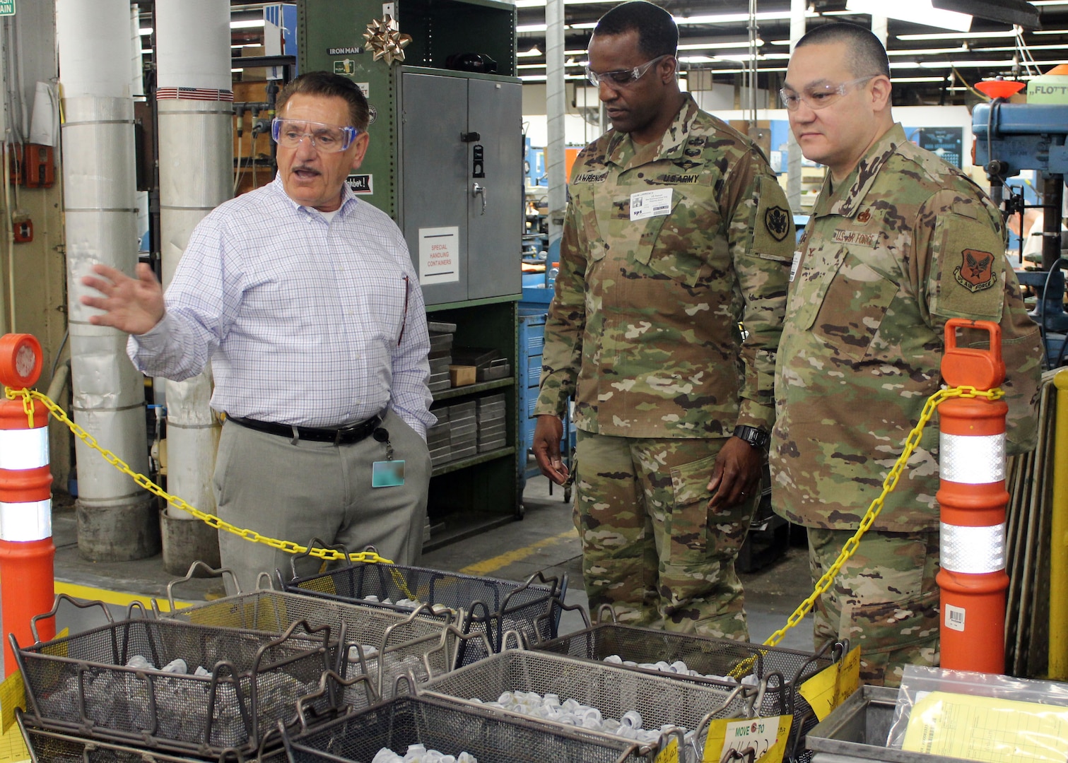 DLA Troop Support Commander Army Brig. Gen. Gavin Lawrence, center, and Industrial Hardware Director Air Force Col. Adrian Crowley, right, listen as SPS Technologies Sales Manager Joseph DiGiacomo explains the manufacturing process that goes into items at the Jenkintown, Pennsylvania facility Feb. 5, 2020.