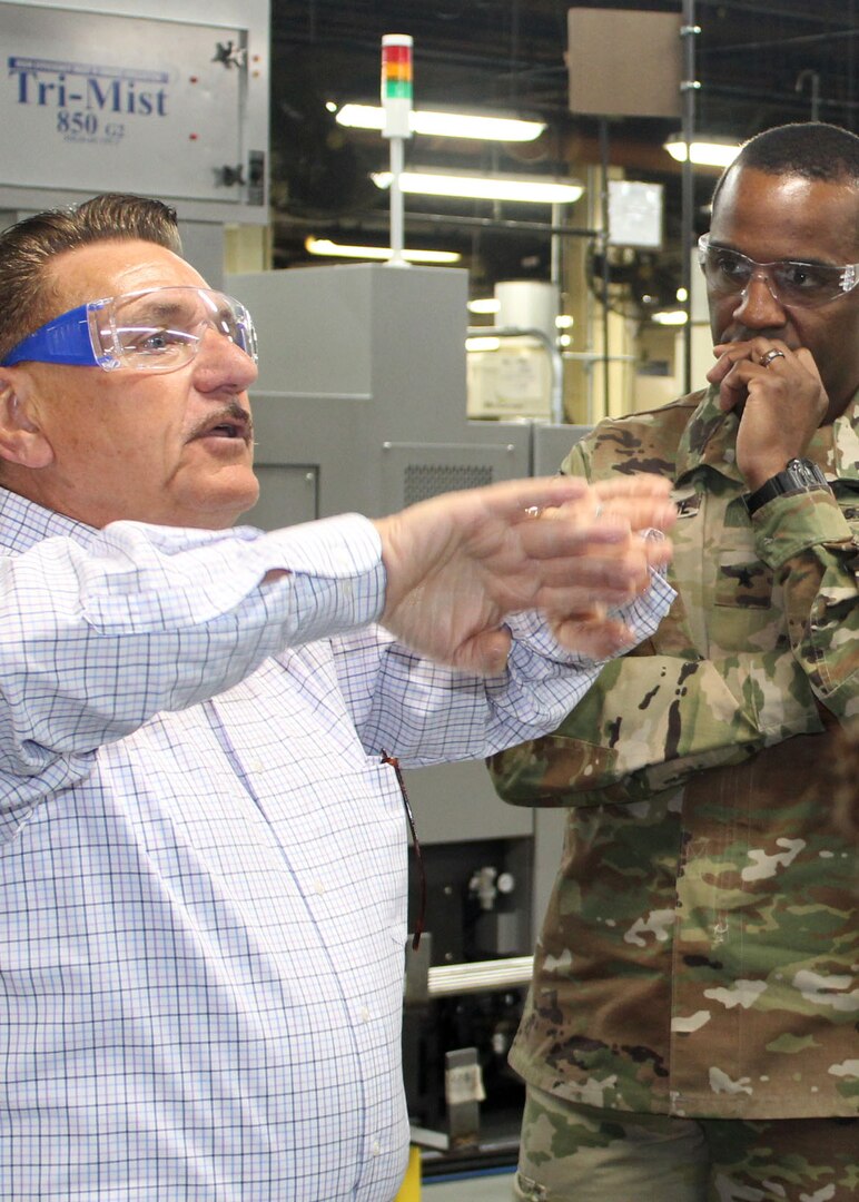 DLA Troop Support Commander Army Brig. Gen. Gavin Lawrence, right, listens as SPS Technologies Sales Manager Joseph DiGiacomo, left, describes a process SPS uses to strengthen the narrower parts of threaded hardware items during a tour of the Jenkintown, Pennsylvania facility Feb. 5, 2020.