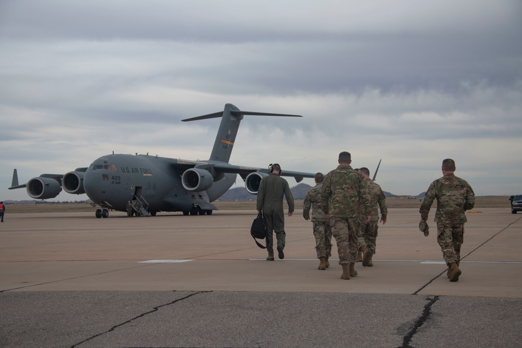 Members of the Oklahoma Commanders Summit walk toward a C-17 Globemaster III