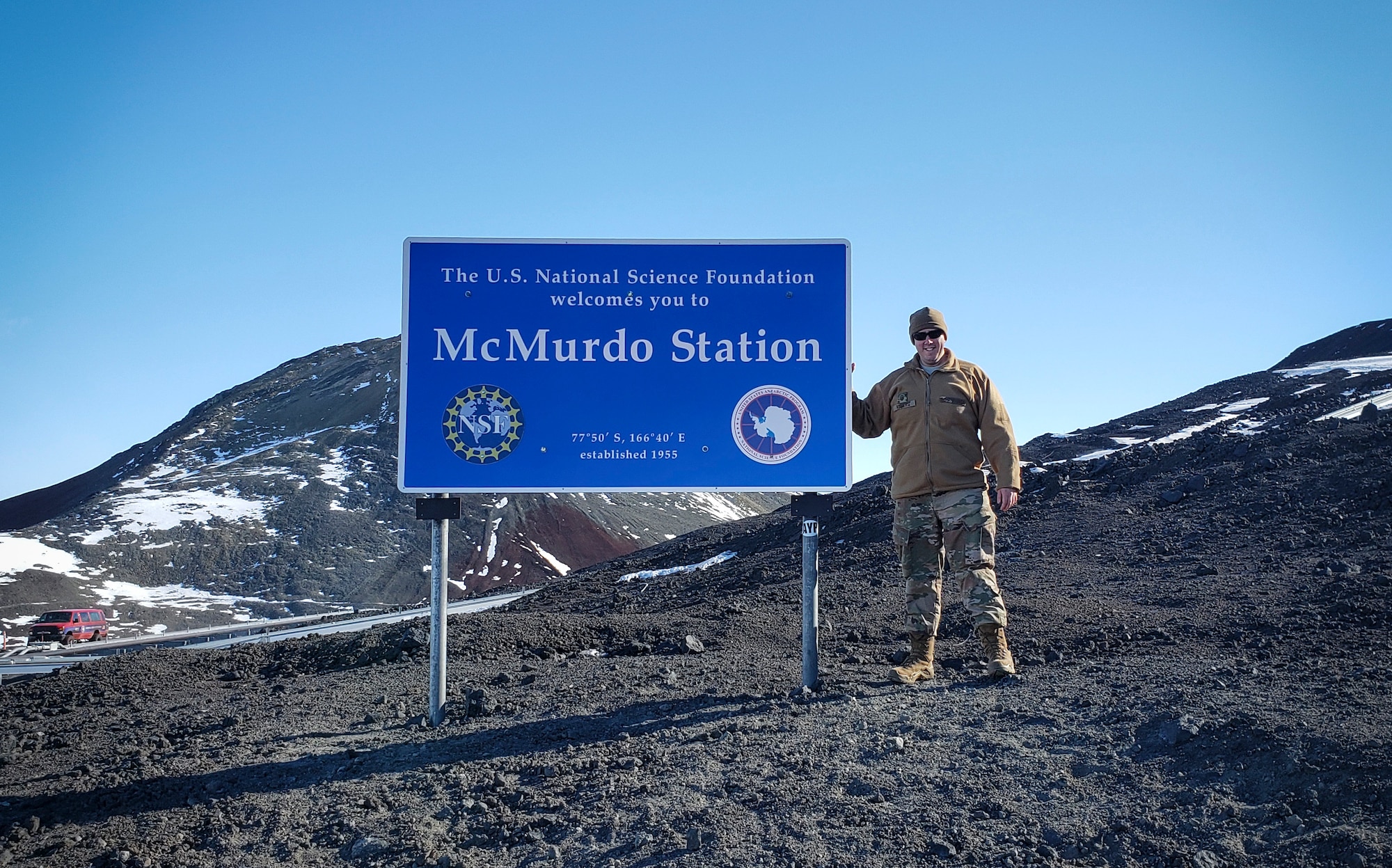 U.S. Air Force Master Sgt. Justin Rogers, an occupational safety specialist, 108th Wing, New Jersey Air National Guard, stands near the marker of McMurdo Station, AN, Nov. 8, 2019 .  Antarctica does not have a military mission, but the National Science Foundation receives airlift support from the 109th Airlift Wing, New York Air National Guard. Rogers backfilled as the 109th safety manager while at McMurdo Station. (Courtesy Photo)