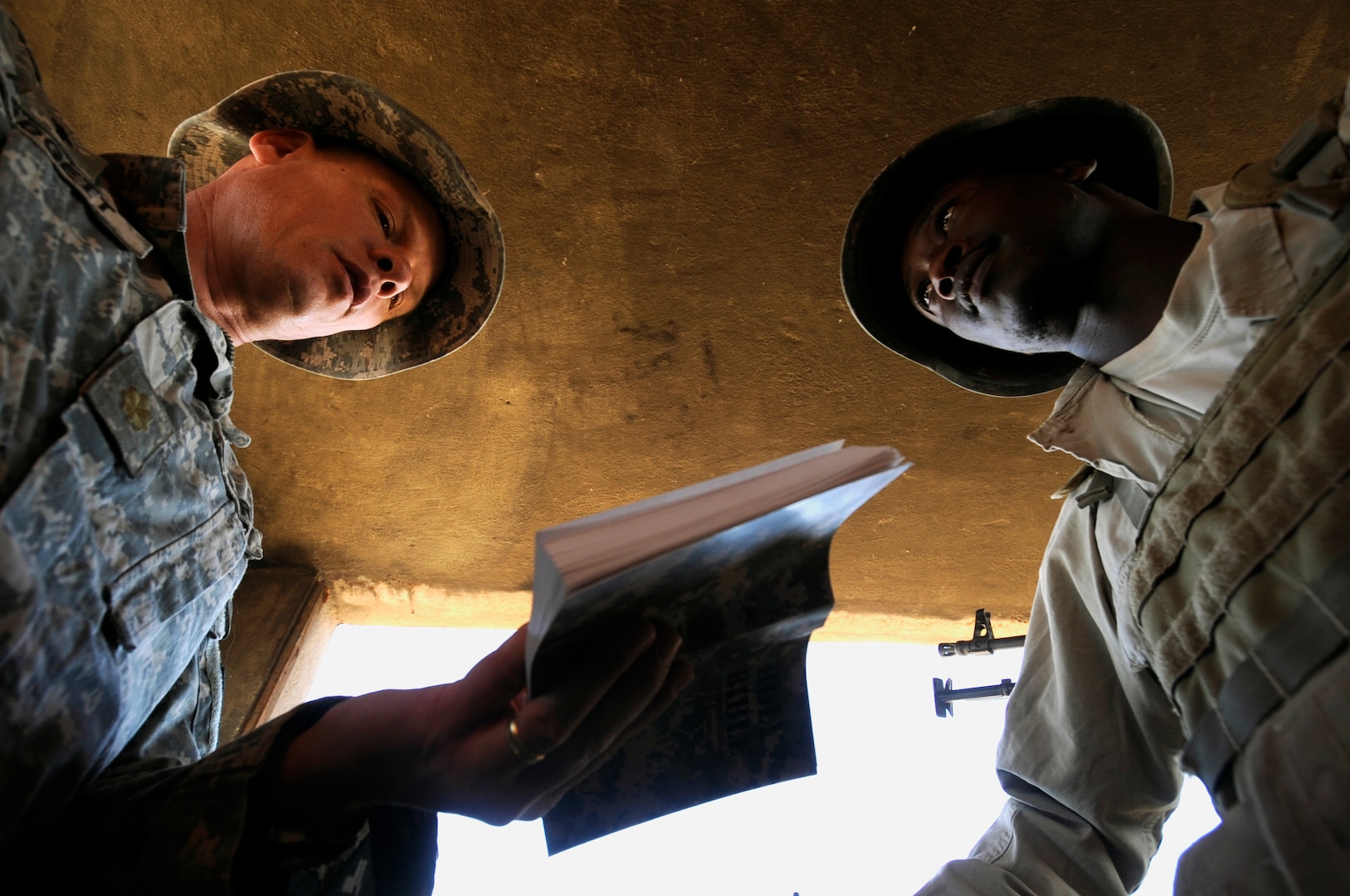 Chaplain with 2nd Battalion, 114th Strike Field Artillery Regiment, Mississippi National Guard, reads passage from Bible during visit with Ugandan security
guards in security tower at Forward Operating Base, Marez, Mosul, Iraq, September 24, 2009 (U.S. Navy/Carmichael Yepez)