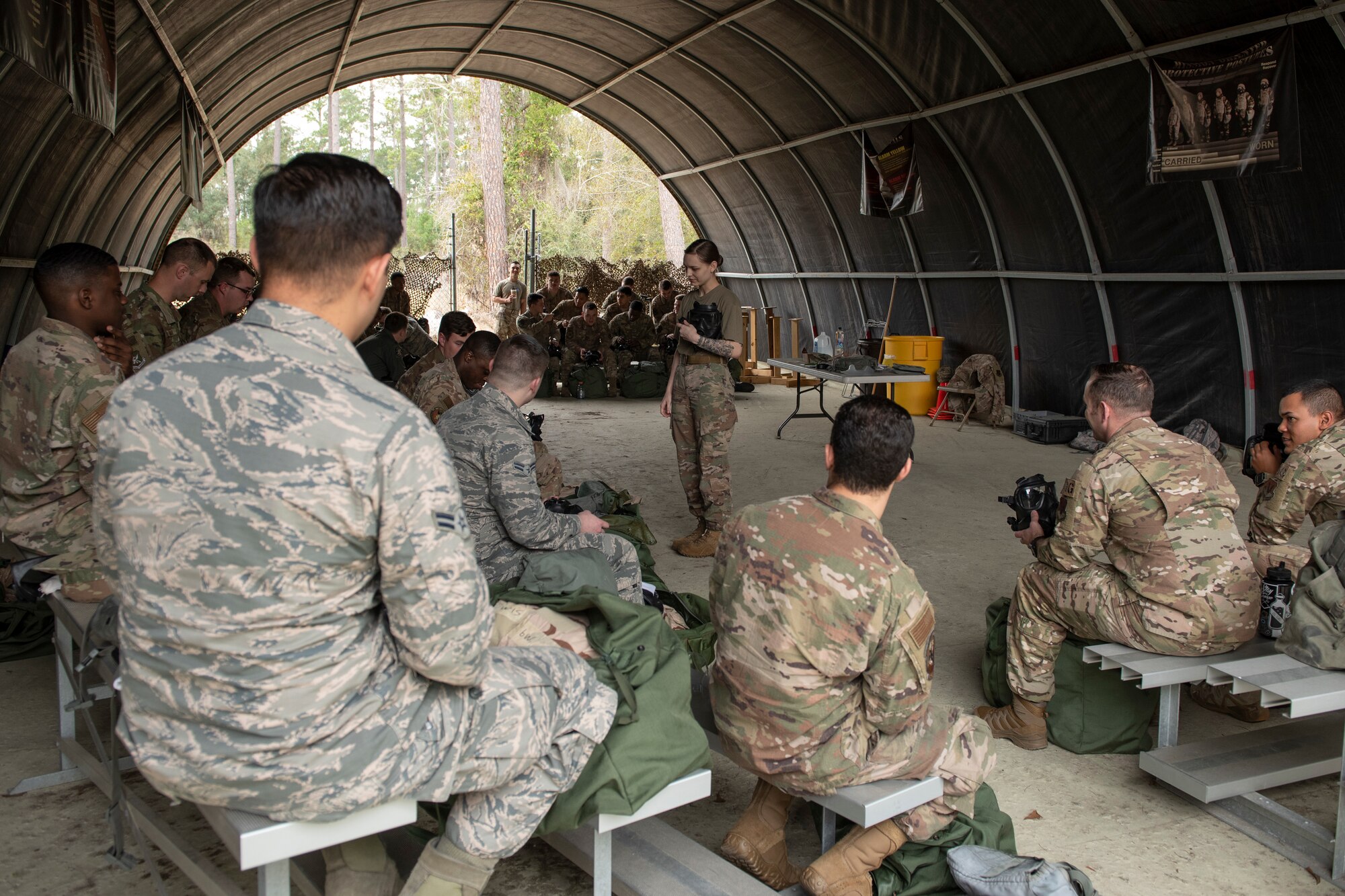 A photo of an Airman instructing Airmen during a chemical, biological, radiological, nuclear, and explosive defense training.