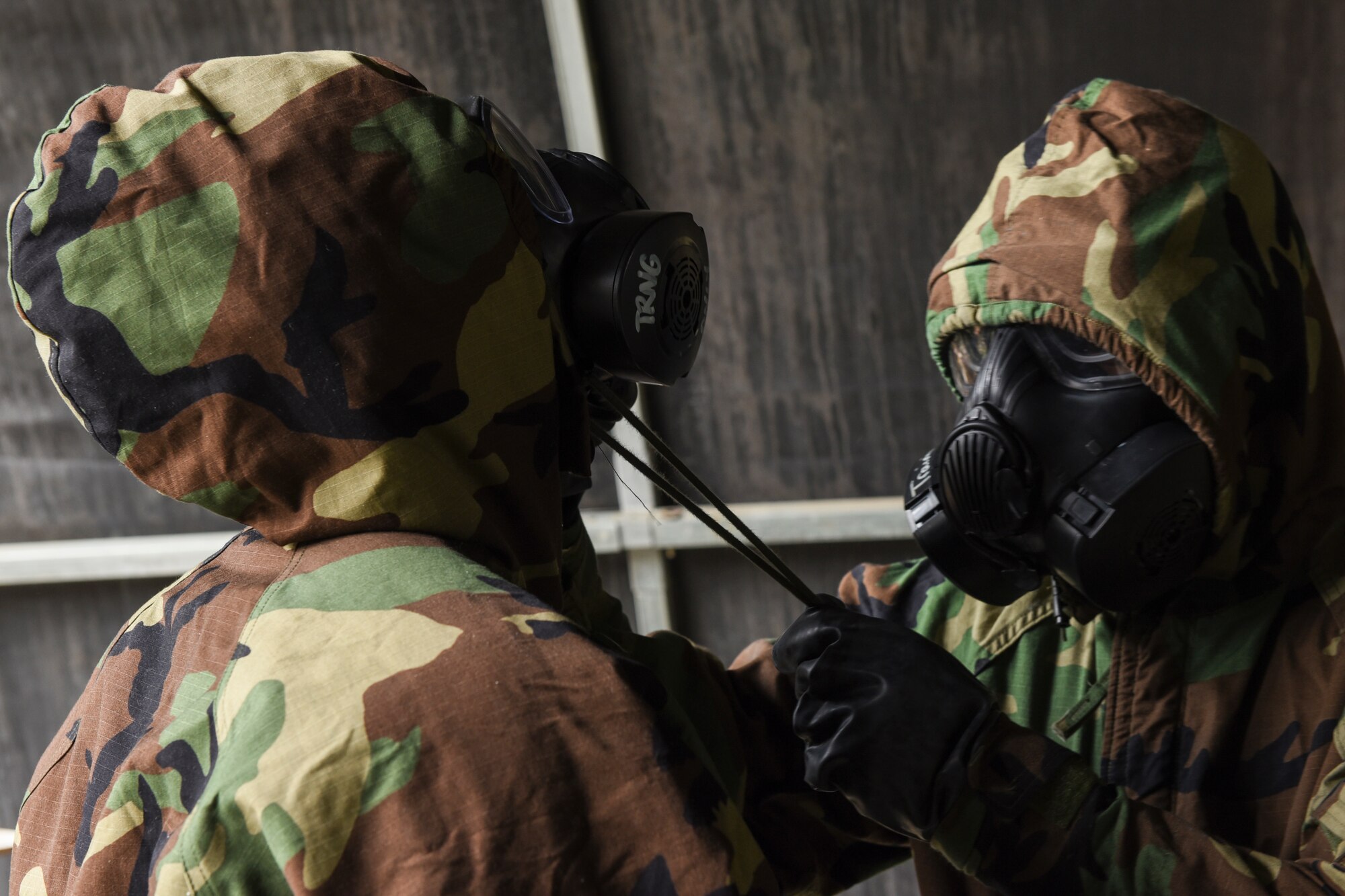 Airmen perform buddy checks during a chemical, biological, radiological, nuclear, and explosive defense training.