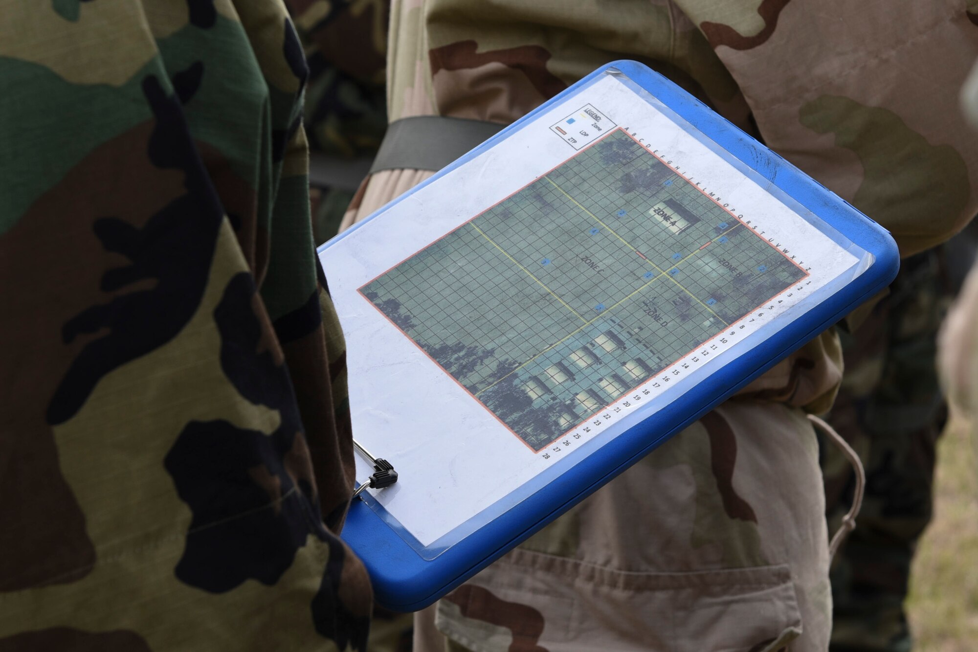 A photo of an Airman reviews a post-attack reconnaissance route map during a chemical, biological, radiological, nuclear, and explosive defense training.