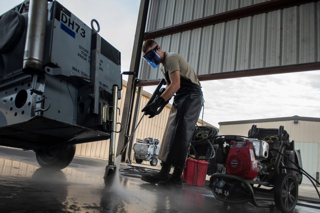 A photo on an Airman washing a generator.