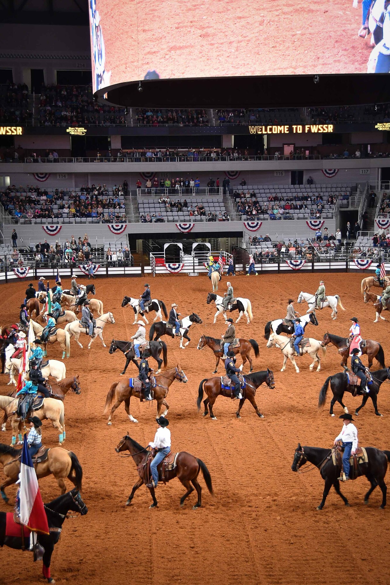 Riders in the Grand Entry weave their way through the six flags of Texas before the rodeo competitions begin at the Fort Worth Stock Show and Rodeo at Dickie’s Arena on February 3, 2020. The FWSSR is the oldest continuously running livestock show and rodeo and has been held annually in Fort Worth, Texas since 1896. (U.S. Air Force Photo by Master Sgt. Jeremy Roman)