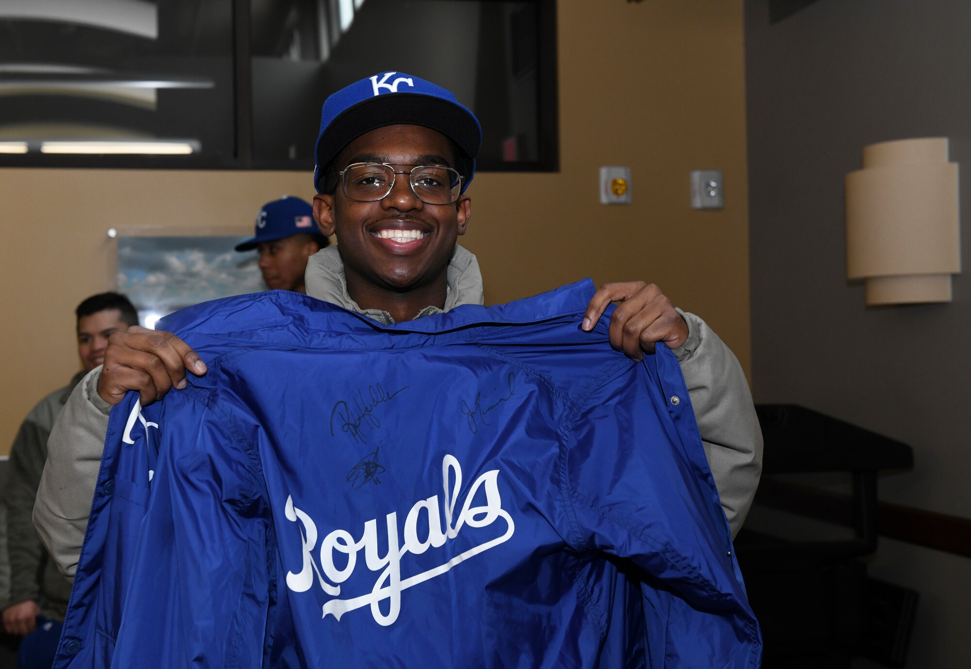 U.S. Air Force Airman 1st Class Marc Minor, a 509th Aircraft Maintenance Squadron weapons load crew member, poses with his Kansas City Royals-signed jacket at Whiteman Air Force Base, Mo., Jan. 30, 2020. Airmen brought various personal items to be signed by the Royals team. (U.S. Air Force photo by Staff Sgt. Sadie Colbert)