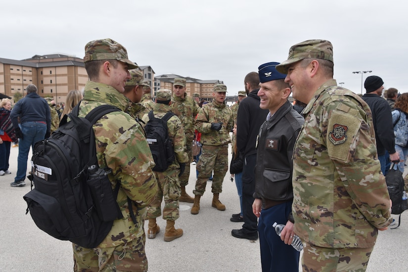 Photo of senior leaders talking with a graduate.