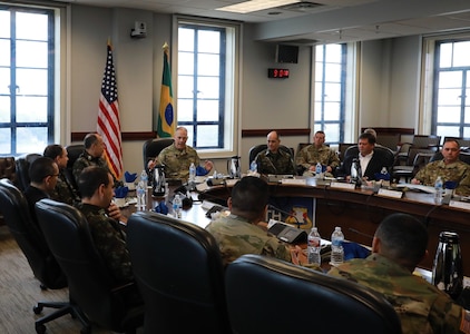 Military personnel sit and talk at a table.