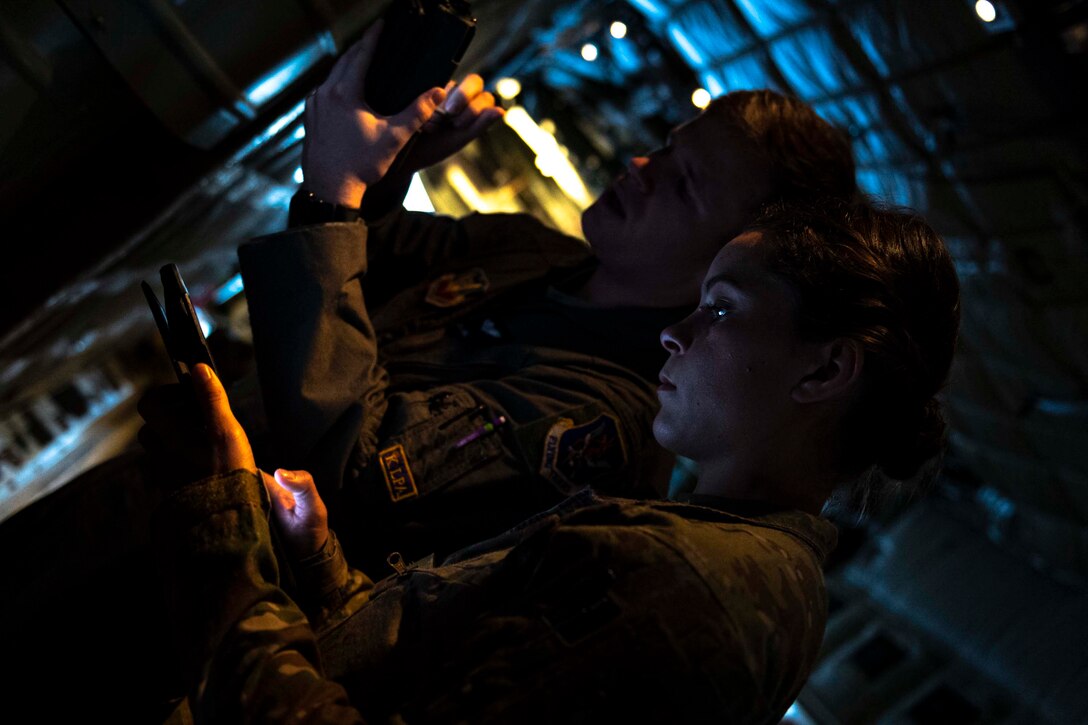 Two airman inspect an aircraft.