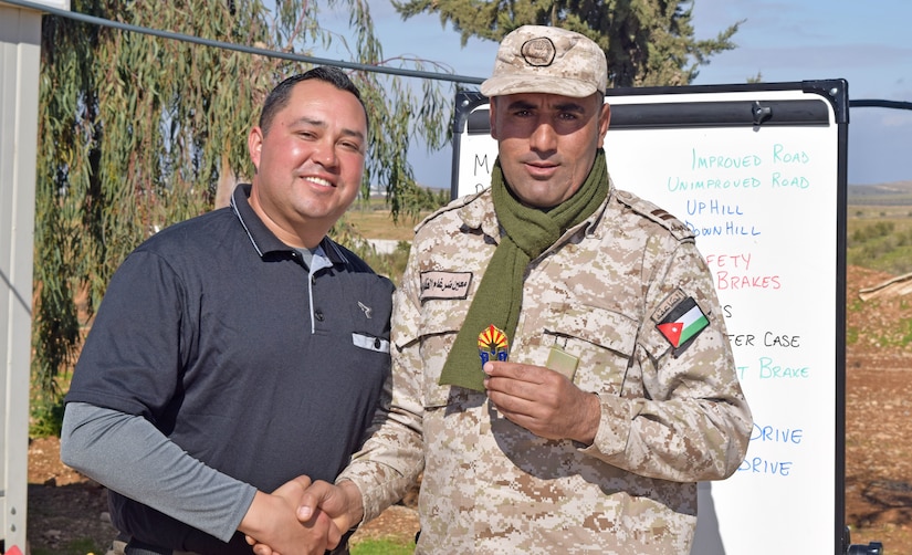 A U.S. Army Soldier (left), with Military Engagement Team-Jordan, 158th Maneuver Enhancement Brigade, Arizona Army National Guard, shakes hands with a Jordan Armed Forces-Arab Army (JAF) Soldier after giving him a unit coin during a Mine Resistant Ambush Protected Wheeled Armored Vehicle Subject Matter Expert Exchange at a base outside of Amman, Jordan in January. The U.S. military has a long-standing relationship with Jordan to support our mutual objectives by providing military assistance to the JAF consistent with our national interests.