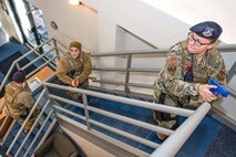 Staff Sgt. Brittany Gorbe, from right, 66th Security Forces Squadron Military Working Dog handler, and Airmen 1st Class Christa Nesbitt and Kenneth Cowperthwait, SFS entry controllers, clear a building during an exercise at Hanscom Air Force Base, Mass., in November 2019. Hanscom AFB will conduct a base exercise scenario of an active shooter situation Feb. 20 to evaluate the installation’s readiness and emergency response capabilities. (U.S. Air Force photo by Todd Maki)