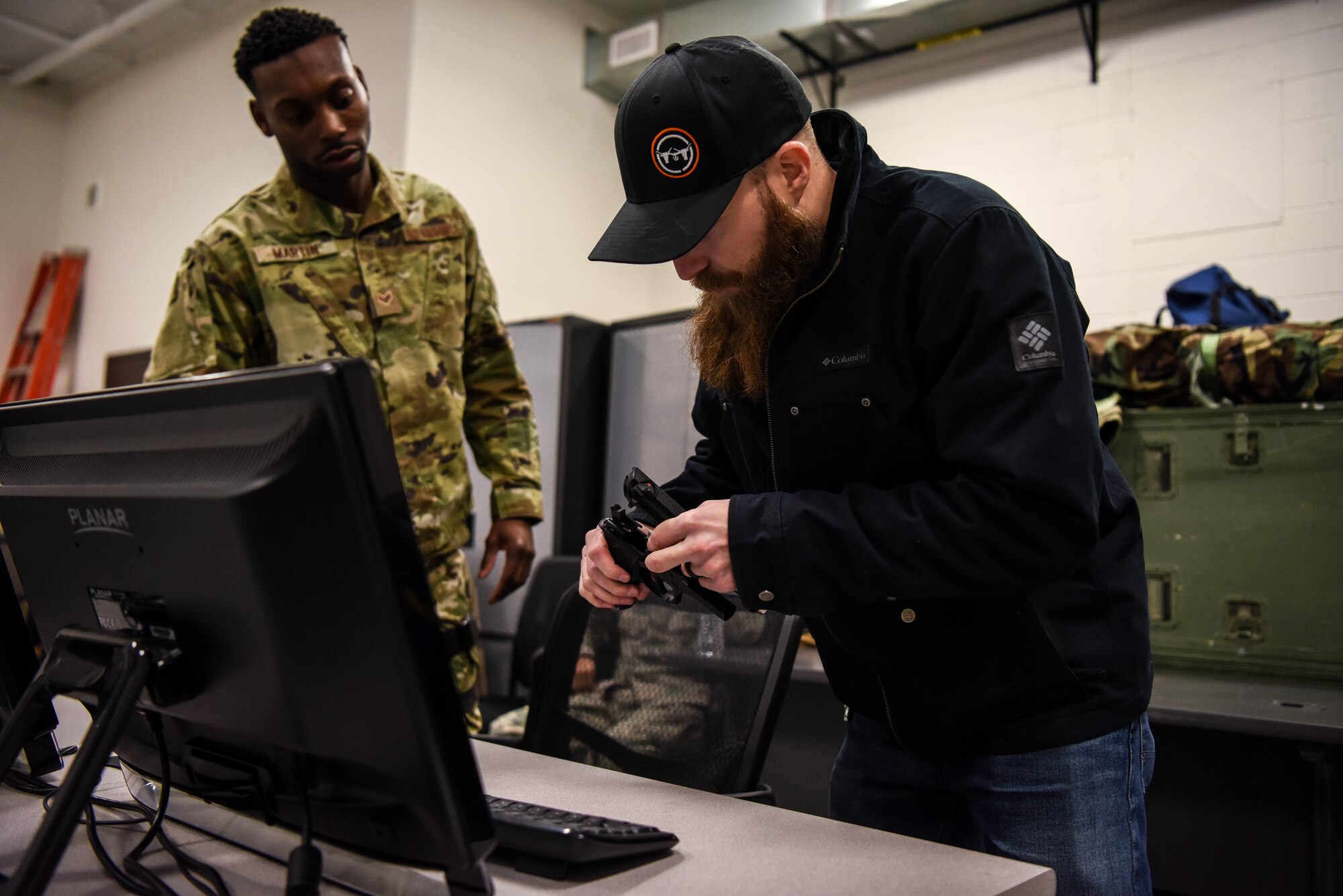 Tim Dixon, 22nd Security Forces Squadron security forces training senior instructor, assembles a trainer 9 mm pistol for use in the multiple interactive learning objective training simulator Feb. 6, 2020, at McConnell Air Force Base, Kansas. The MILO is a multiple scenario simulator that allows security forces members to practice and train on the use of force. (U.S. Air Force photo by Airman 1st Class Marc A. Garcia)