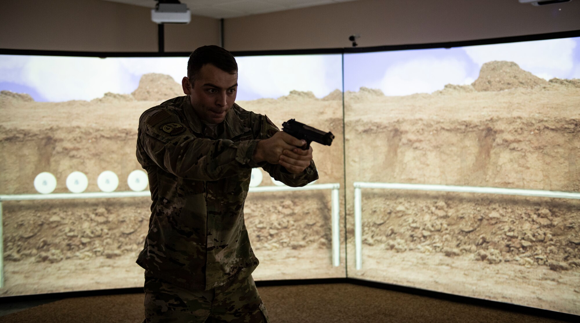 U.S. Air Force Staff Sgt. Thomas Badders, 325th Security Forces Squadron non-commissioned officer in charge of confinement, shoots at virtual targets at Tyndall Air Force Base, Florida, Feb. 5, 2020. Security Forces uses the Multiple Interactive Learning/Training Objectives Range to hone their skills without the need to fire live rounds. (U.S. Air Force photo by Senior Airman Stefan Alvarez)