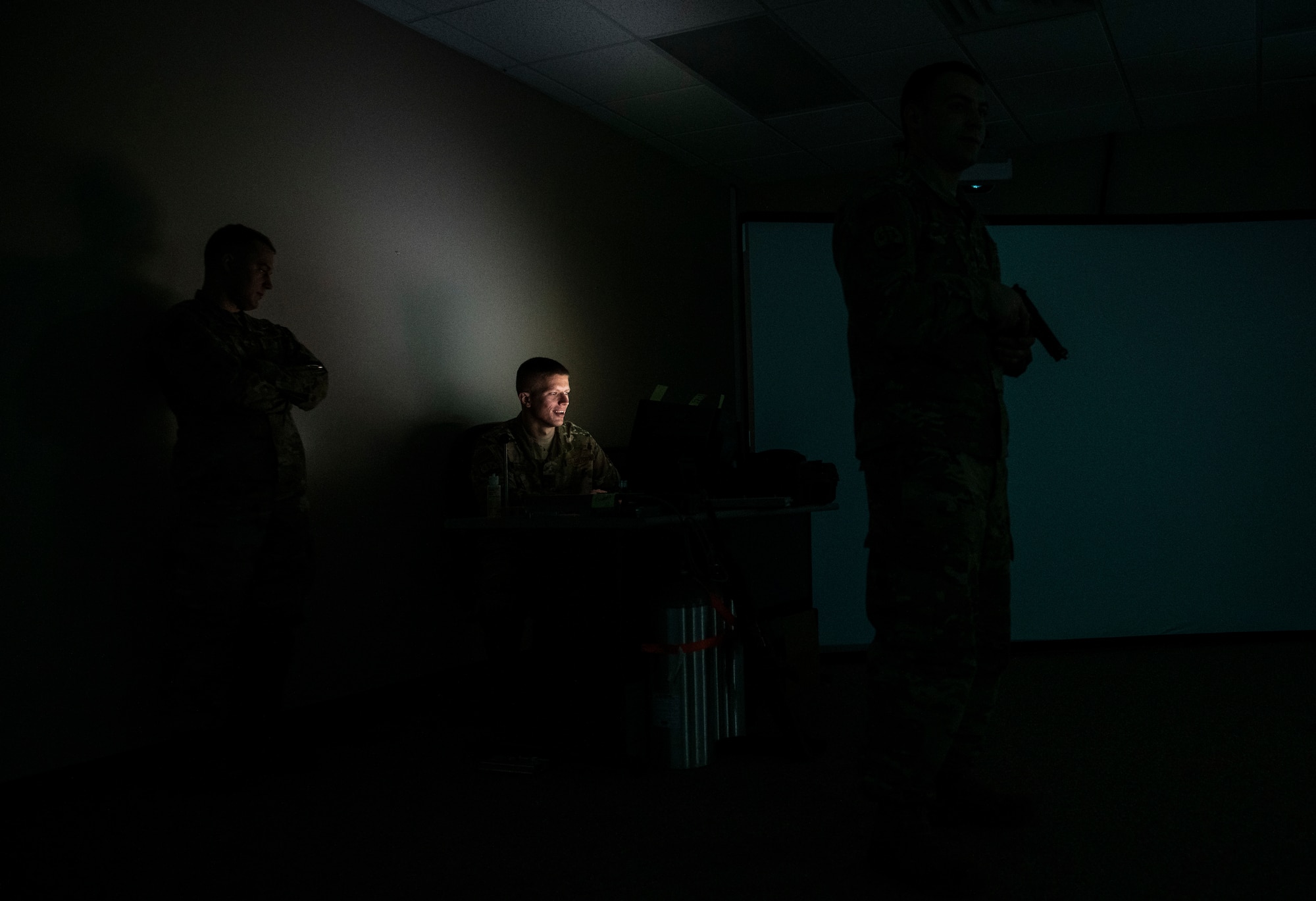 U.S. Air Force Staff Sgt. Michael McDowell, 325th Security Forces Squadron standards and evaluations evaluator (center), prepares a training scenario for Staff Sgt. Thomas Badders, 325th SFS noncommissioned officer in charge of confinement, at Tyndall Air Force Base, Florida, Feb. 5, 2020. Security Forces uses the Multiple Interactive Learning/Training Objectives Range to train for real-world situations. (U.S. Air Force photo by Senior Airman Stefan Alvarez)