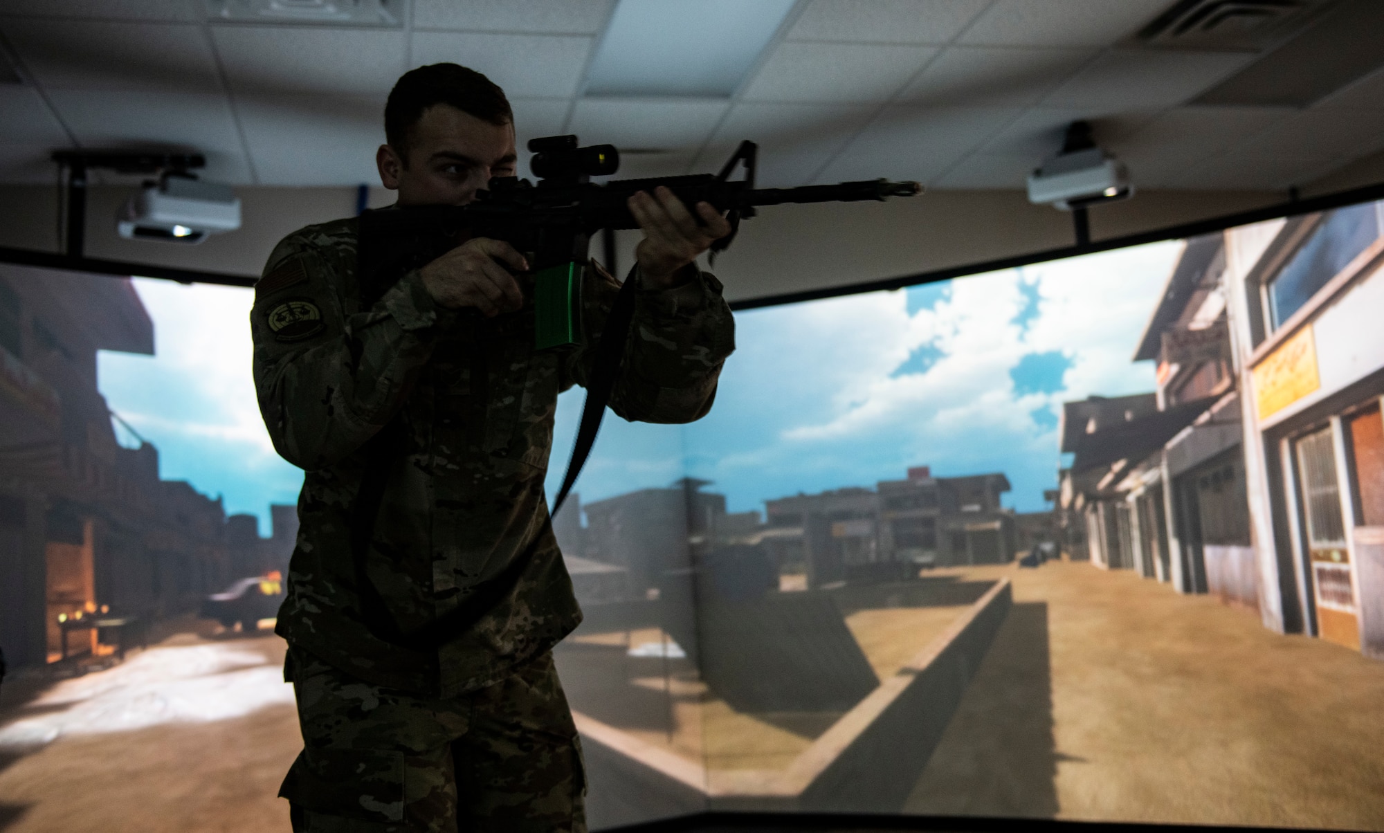 U.S. Air Force Staff Sgt. Thomas Badders, 325th Security Forces Squadron noncommissioned officer in charge of confinement, shoots at virtual targets at Tyndall Air Force Base, Florida, Feb. 5, 2020. Security Forces uses the Multiple Interactive Learning/Training Objectives Range to hone their skills without the need to fire live rounds. (U.S. Air Force photo by Senior Airman Stefan Alvarez)