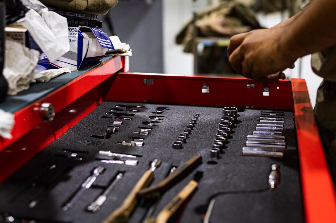 A photo of an Airman taking a tool from a tool chest.