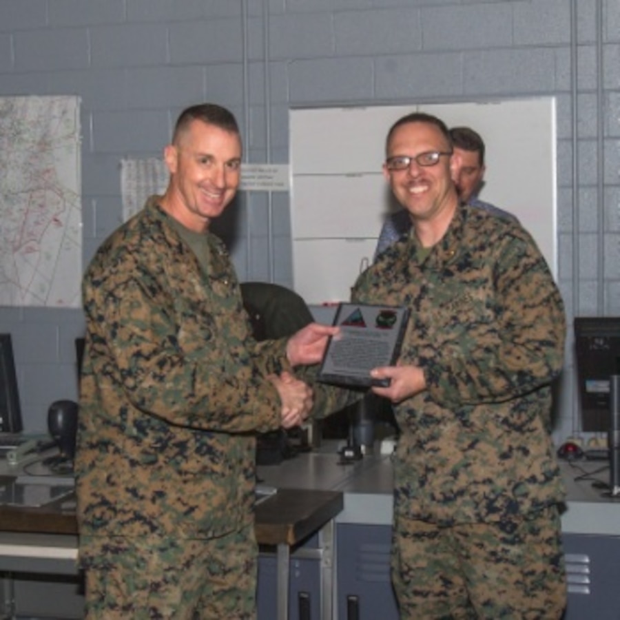 U.S. Marine Corps Col. Darry Grossnickle, commanding officer of Marine Air Control Group (MACG) 28, gives Maj. Brian Taylor, officer-in-charge of Marine Corps Air Station (MCAS) Cherry Point Air Traffic Control (ATC), a plaque recognizing the ATC personnel for their classroom efforts, instruction, simulation performance and live-flight training of the group's air traffic controllers. The facility continuously provides MACG-28 and Marine Air Control Squadron 2 with certified and highly qualified air traffic controllers.