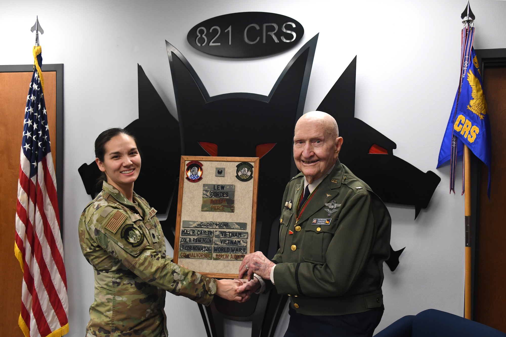 U.S. Air Force Lt. Col. Christina Lee, 821st Contingency Response Squadron commander, and retired Col. Gail S. Halvorsen, hold a plaque which displays Halvorsen’s name in recognition of his legacy as Berlin’s Candy Bomber, Jan. 31, 2020, Travis Air Force Base, California. The 99-year old war hero shared his amazing story with the Airmen and as a tribute to his legacy, he was inducted into the squadron's "Super Howl" hall of fame. The Super-Howl was initiated by the squadron as a way to recognize military veterans who visit their unit and have played an important role in the nation’s history. The squadron displays this honor on a plaque at the unit where they add the name of the inductee next to the operation he or she served in. (U.S. Air Force photo/ TSgt Liliana Moreno)