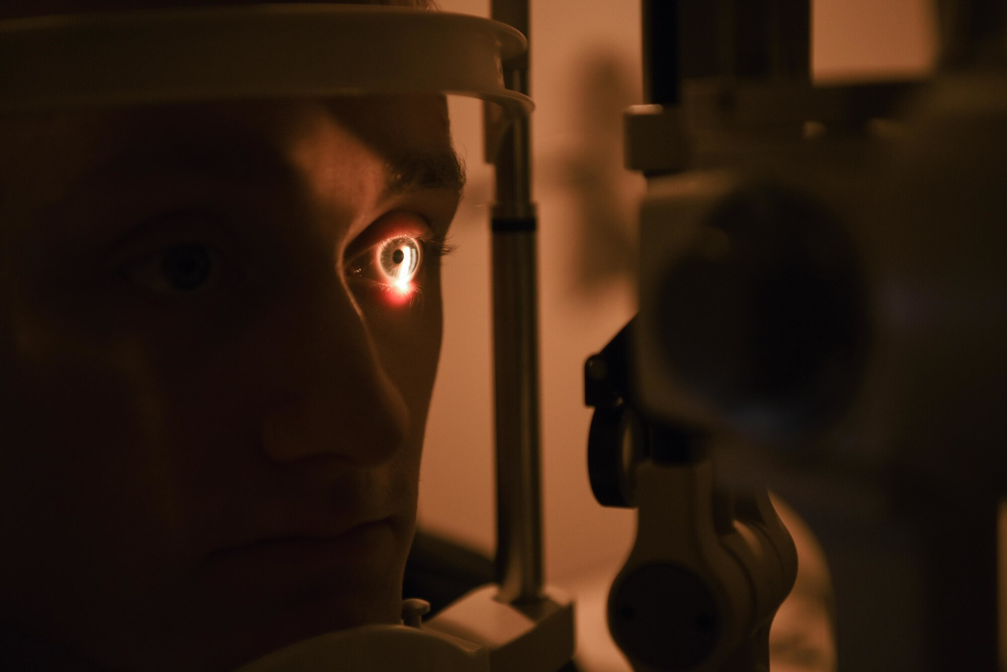 Senior Airman gets his eyes checked using a slit lamp