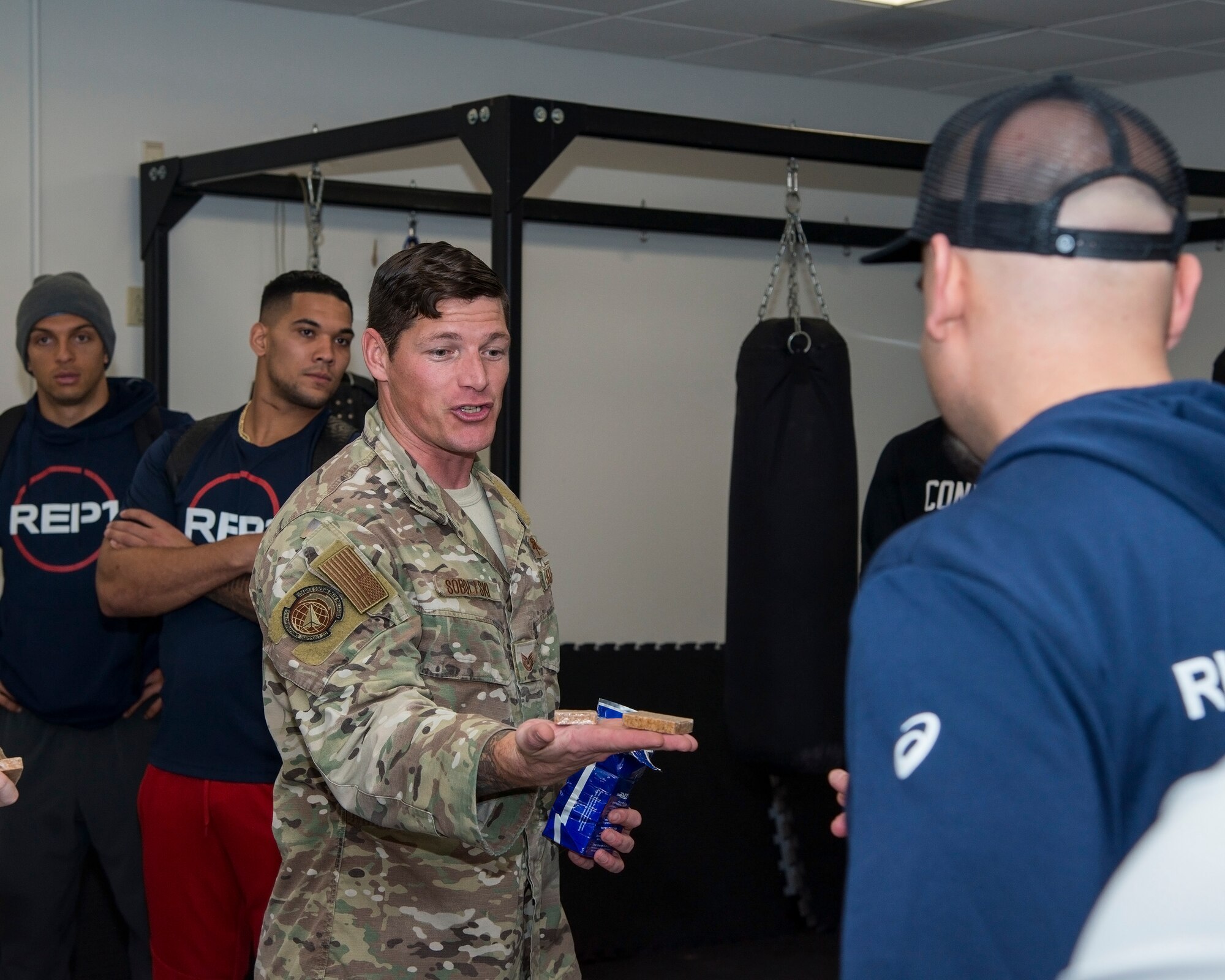 U.S. Air Force Tech. Sgt. Jesse Soboleski, a Survival, Evasion, Resistance and Escape (SERE) noncommissioned officer in charge, hands out meal rations to professional athletes touring MacDill Air Force Base, Fla., Jan. 28, 2020.