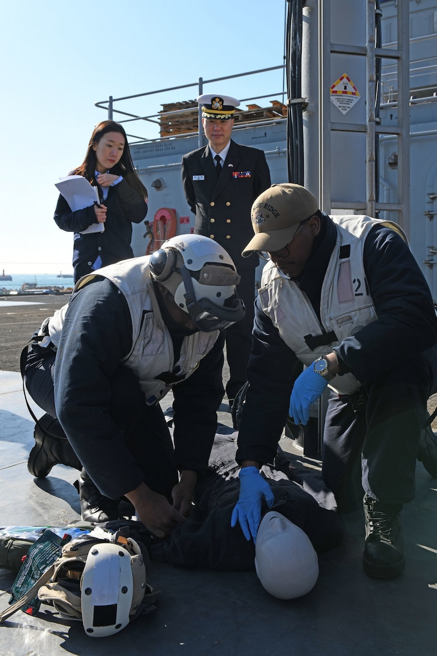 Hospital Corpsman 3rd Class William Powell, from Little Rock, Arkansas, and Hospital Corpsman 3rd Class Darius Moody, from Fort Walton Beach, Florida, demonstrate how to assess a simulated casualty as part of a medical demonstration held for Republic of Korea Navy medical personnel aboard U.S. 7th Fleet flagship, USS Blue Ridge. Blue Ridge with embarked U.S. 7th Fleet Sailors arrived in Busan, Republic of Korea (ROK) for a regularly scheduled port visit Feb. 5. During their visit they will engage in local culture, host military-to-military engagements and build relationships through music and public service activities.