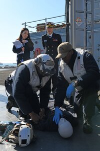 Hospital Corpsman 3rd Class William Powell, from Little Rock, Arkansas, and Hospital Corpsman 3rd Class Darius Moody, from Fort Walton Beach, Florida, demonstrate how to assess a simulated casualty as part of a medical demonstration held for Republic of Korea Navy medical personnel aboard U.S. 7th Fleet flagship, USS Blue Ridge. Blue Ridge with embarked U.S. 7th Fleet Sailors arrived in Busan, Republic of Korea (ROK) for a regularly scheduled port visit Feb. 5. During their visit they will engage in local culture, host military-to-military engagements and build relationships through music and public service activities.