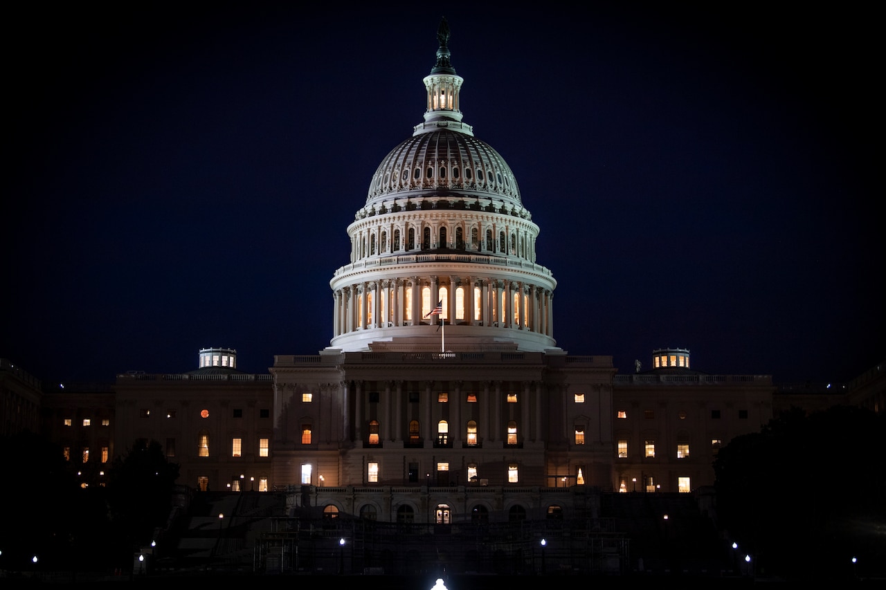 Lights illuminate the U.S. Capitol against a dark sky.