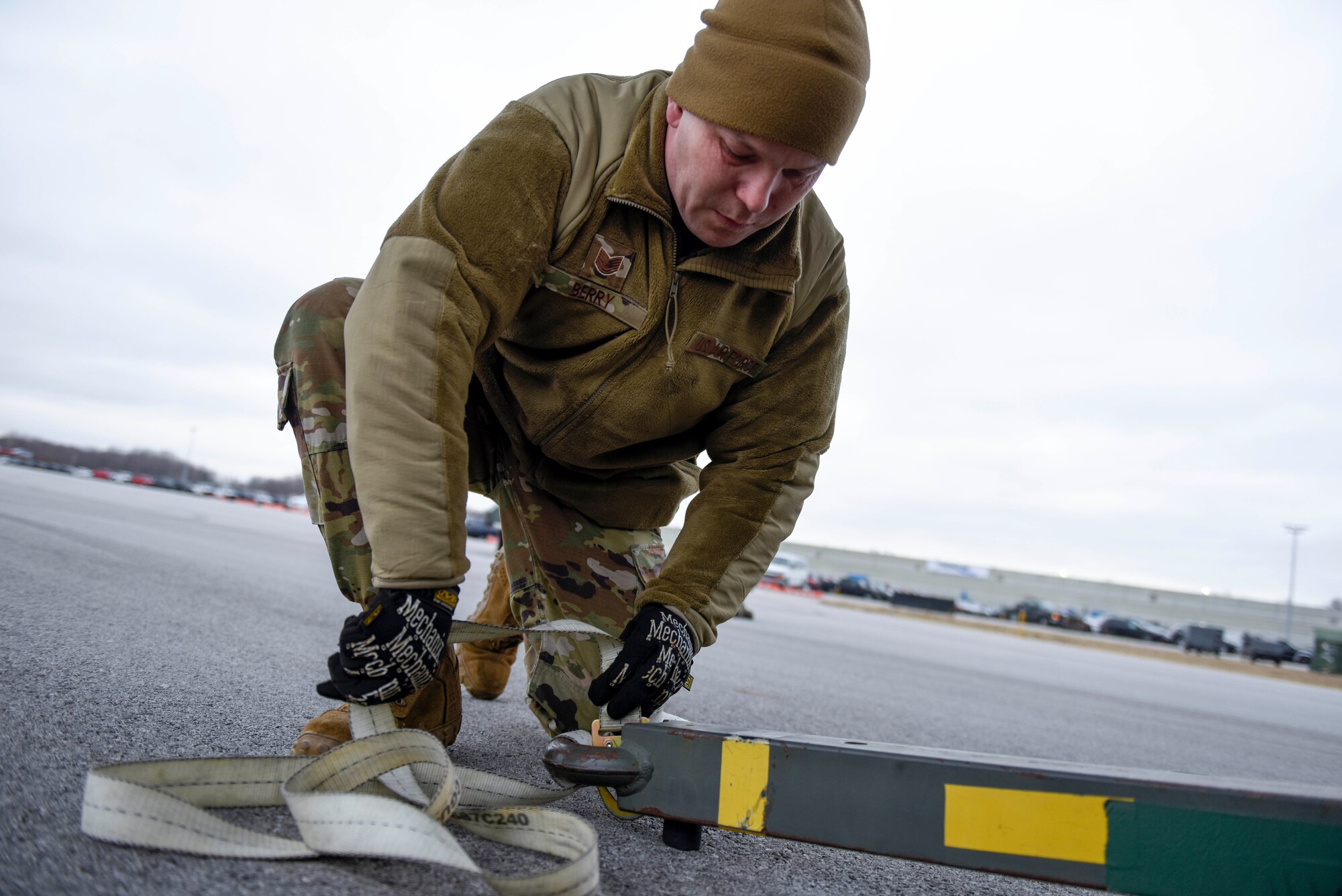 U.S. Air Force Tech. Sgt. Adam Berry, a vehicle maintenance technician assigned to the 180FW, ties a strap to cargo to help load it onto a C-17 assigned to the 167th AW at the 180FW, Feb. 4, 2020. The C-17 was loaded with equipment to support the 180FW's involvement in exercise Green Flag-West. Green flag is a realistic, Air-to-Surface, joint training exercise designed to improve interoperability between aircraft while supporting ground troops by allowing U.S. military branches, as well as other NATO and allied nations, an opportunity to work together, as they would in military operations around the world.
