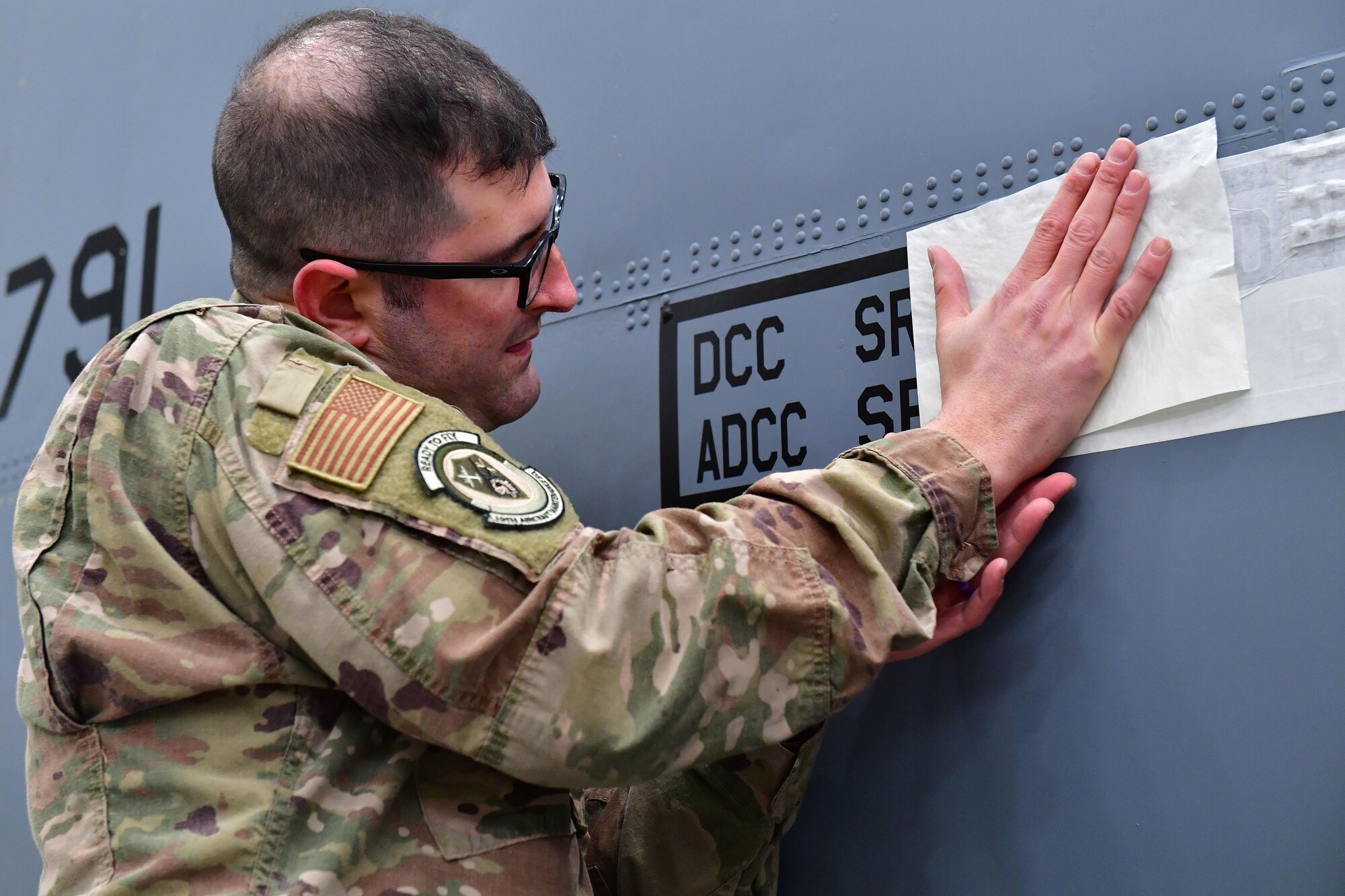 Senior Airman Kahlin Dawson, 19th Aircraft Maintenance Squadron crew chief, unveils his name on his assigned aircraft as part of the Dedicated Crew Chief program.