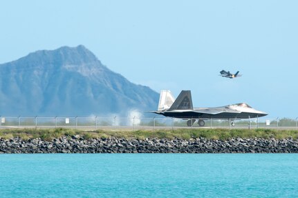 A Hawaii Air National Guard F-22 Raptor taxis down the Honolulu Airport Runway Jan. 29, 2020, as an F-35A Lightning II takes off.