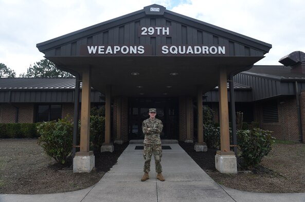 A man stands in front of a building.
