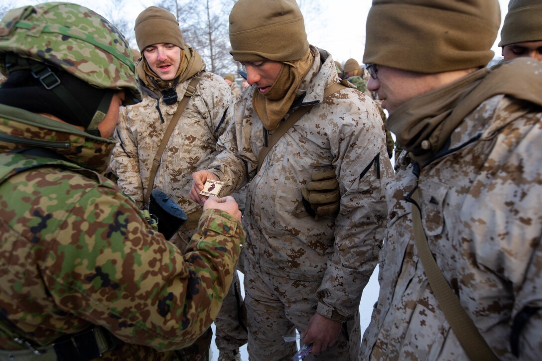 U.S. Marines with 1st Battalion, 25th Marine Regiment, and members of the 5th Brigade, Japan Ground Self-Defense Force, exchange gifts after the ceremony concluding the end of exercise Northern Viper on Yausubetsu Training Area, Hokkaido, Japan, Feb. 8.
