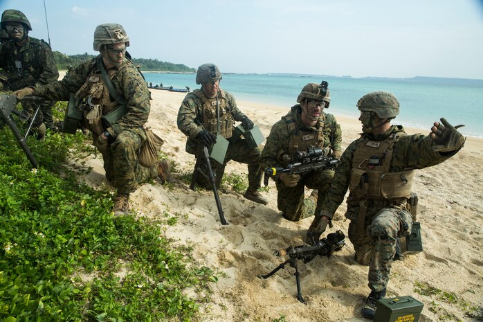 Marines with Charlie Company, Battalion Landing Team, 1st Battalion 5th Marines, 31st Marine Expeditionary Unit, and Japanese Amphibious Rapid Deployment Brigade service members communicate during a simulated bilateral small-boat raid on Kin Blue, Okinawa, Japan, Feb. 9.