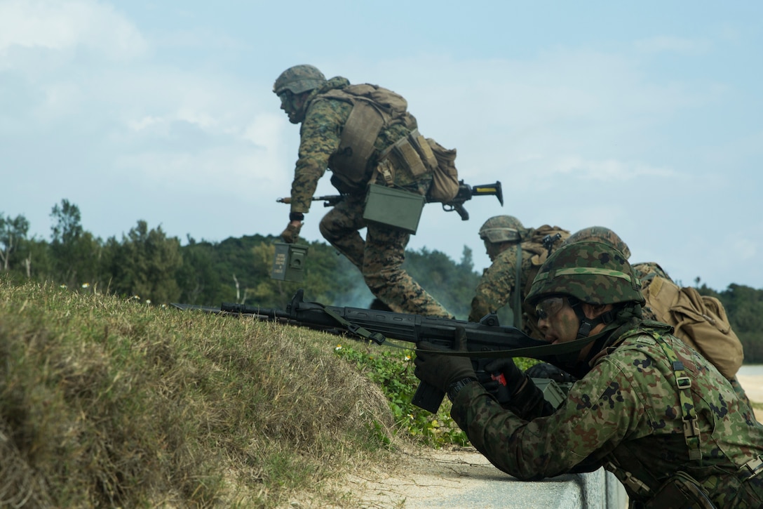 Marines with Charlie Company, Battalion Landing Team, 1st Battalion 5th Marines, 31st Marine Expeditionary Unit, and Japanese Amphibious Rapid Deployment Brigade service members maneuver toward the objective during a simulated bilateral small-boat raid on Kin Blue, Okinawa, Japan, Feb. 9.