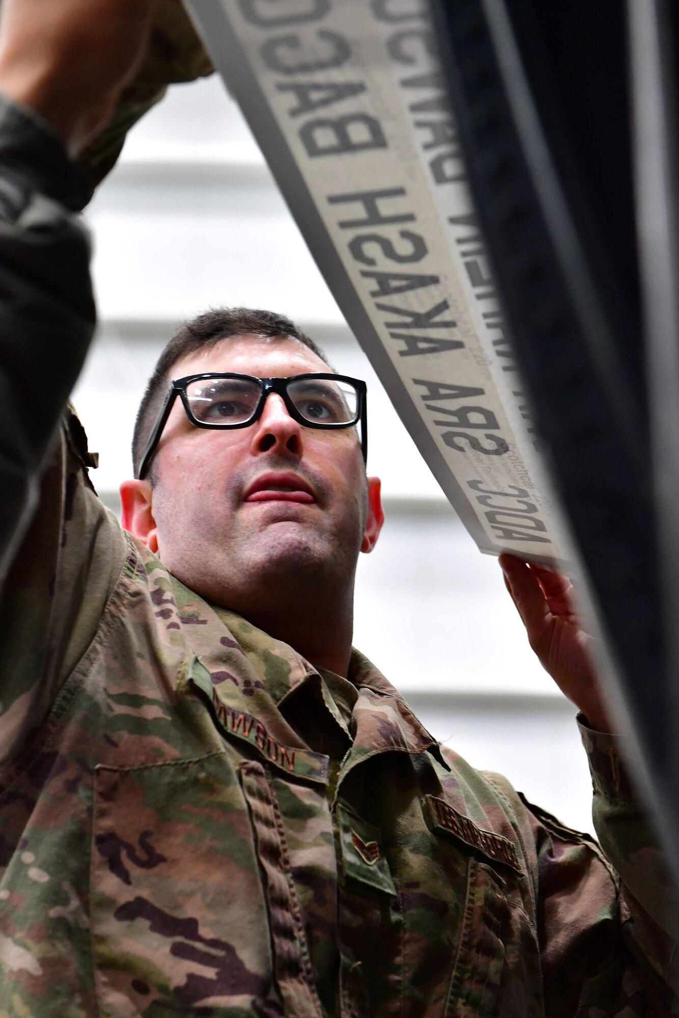 Senior Airman Kahlin Dawson, 19th Aircraft Maintenance Squadron crew chief, unveils his name on his assigned aircraft as part of the Dedicated Crew Chief program.